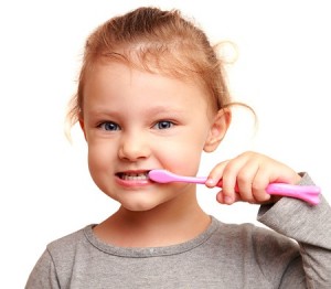 child brushing teeth after eating holiday treats