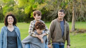 Teen boys walking outdoors with their parents, representing family support, teen dental health, and ongoing pediatric dental care during adolescence.