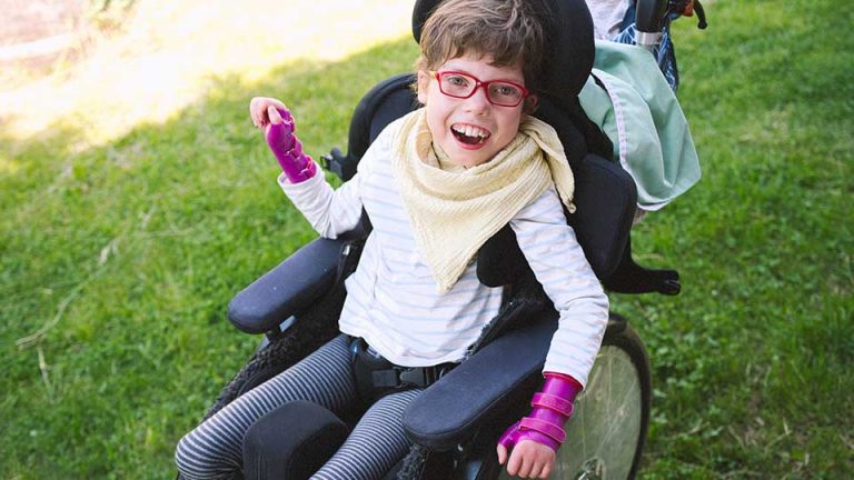 child with special needs in wheelchair smiling
